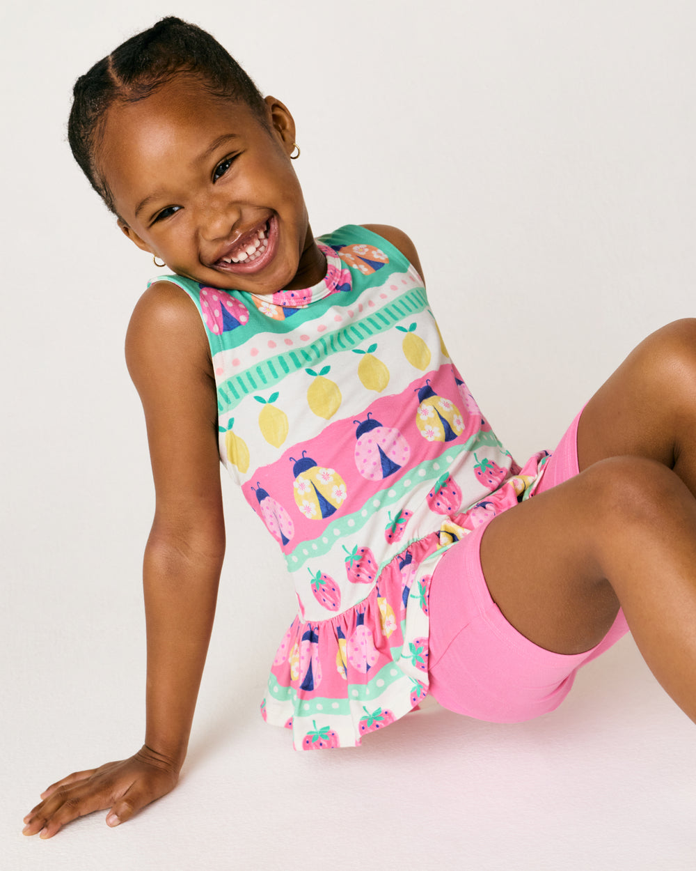 Sitting girl wearing the Ladybug Lane Peplum Tank