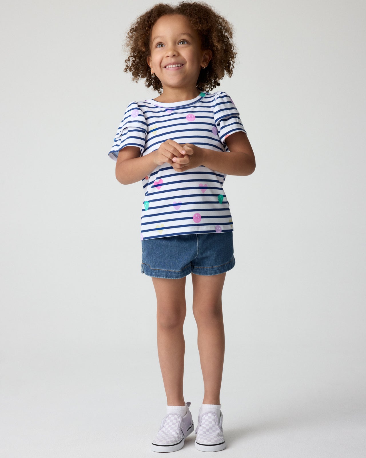 Girl wearing the Smiley Stripes Double Flutter Tee with denim shorts