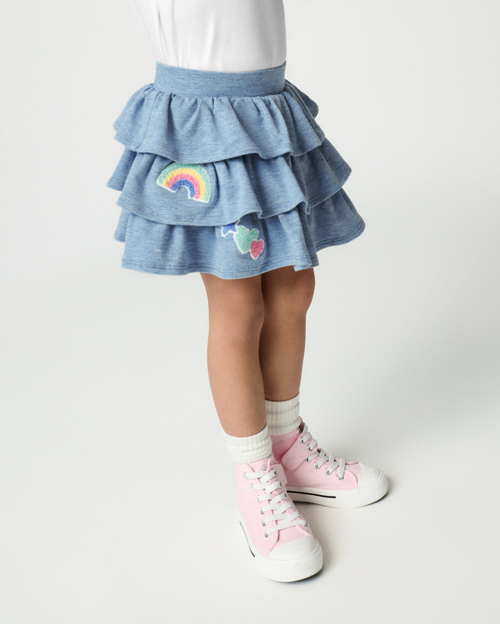 Girl wearing the Smiley Face Tiered Skort with pink sneakers