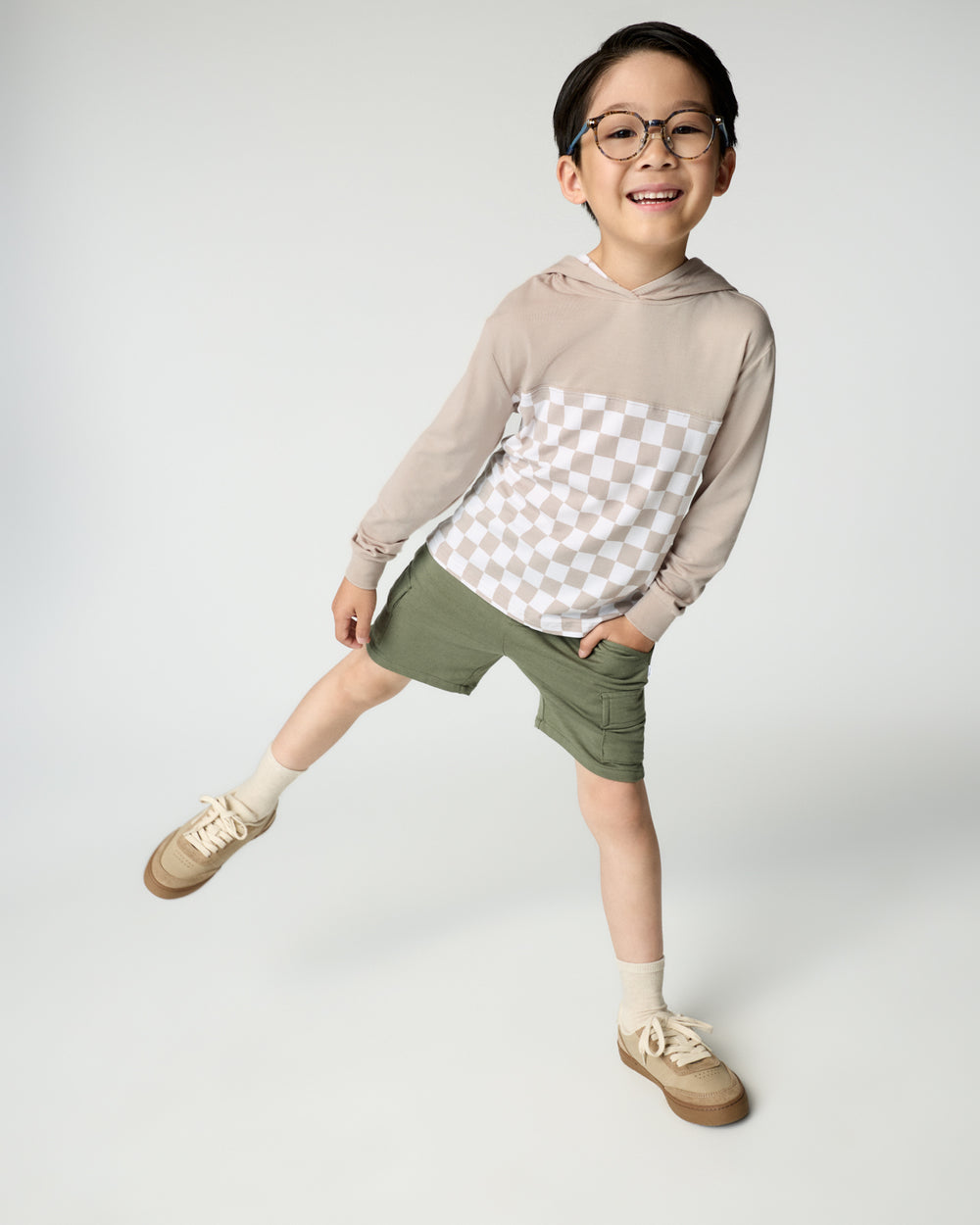 Boy wearing the Stone Checks Relaxed Hooded Tee with green cargo shorts