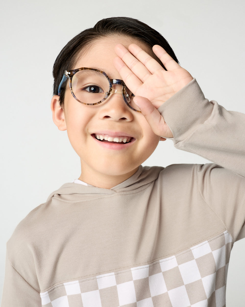 Close up of boy showing the thumb hole detail on the Stone Checks Relaxed Hooded Tee