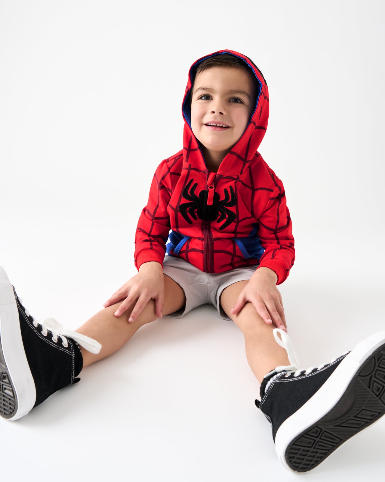 Sitting boy wearing the Spiderman Zip Hoodie