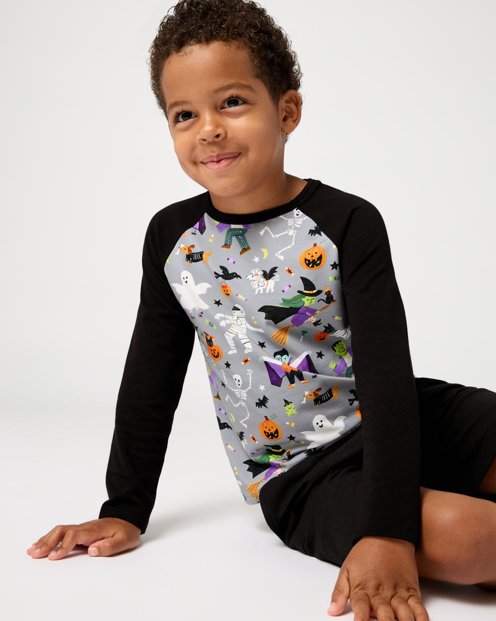 Sitting boy wearing the Dracula's Disco Raglan Tee