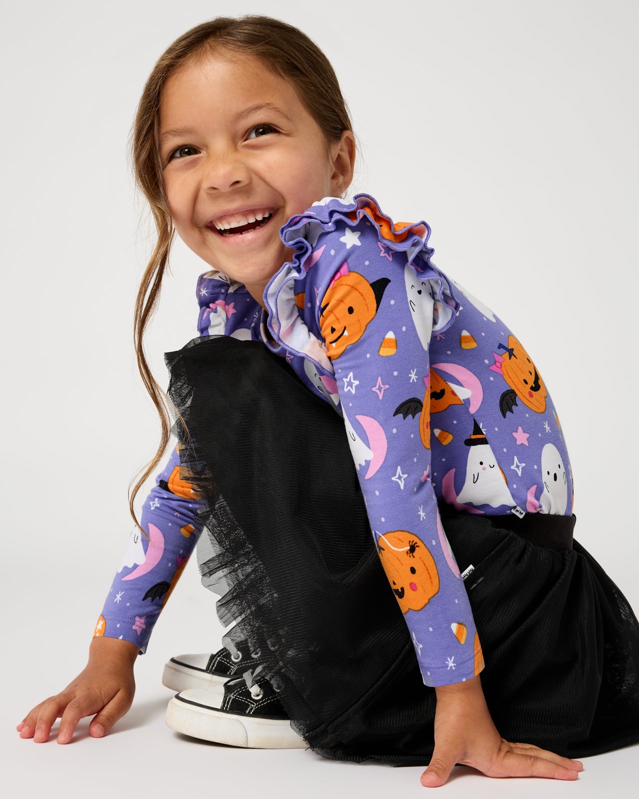 Crouching girl wearing the Black Tutu Legging with a purple halloween top
