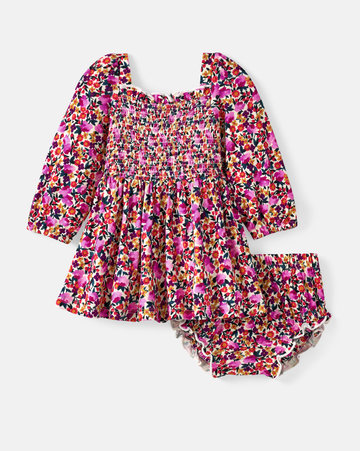 A baby girl's two-piece outfit featuring a smocked long-sleeve dress and matching ruffled bloomers, both in a vibrant pink, orange, yellow, and black floral pattern, displayed on a light gray background.
