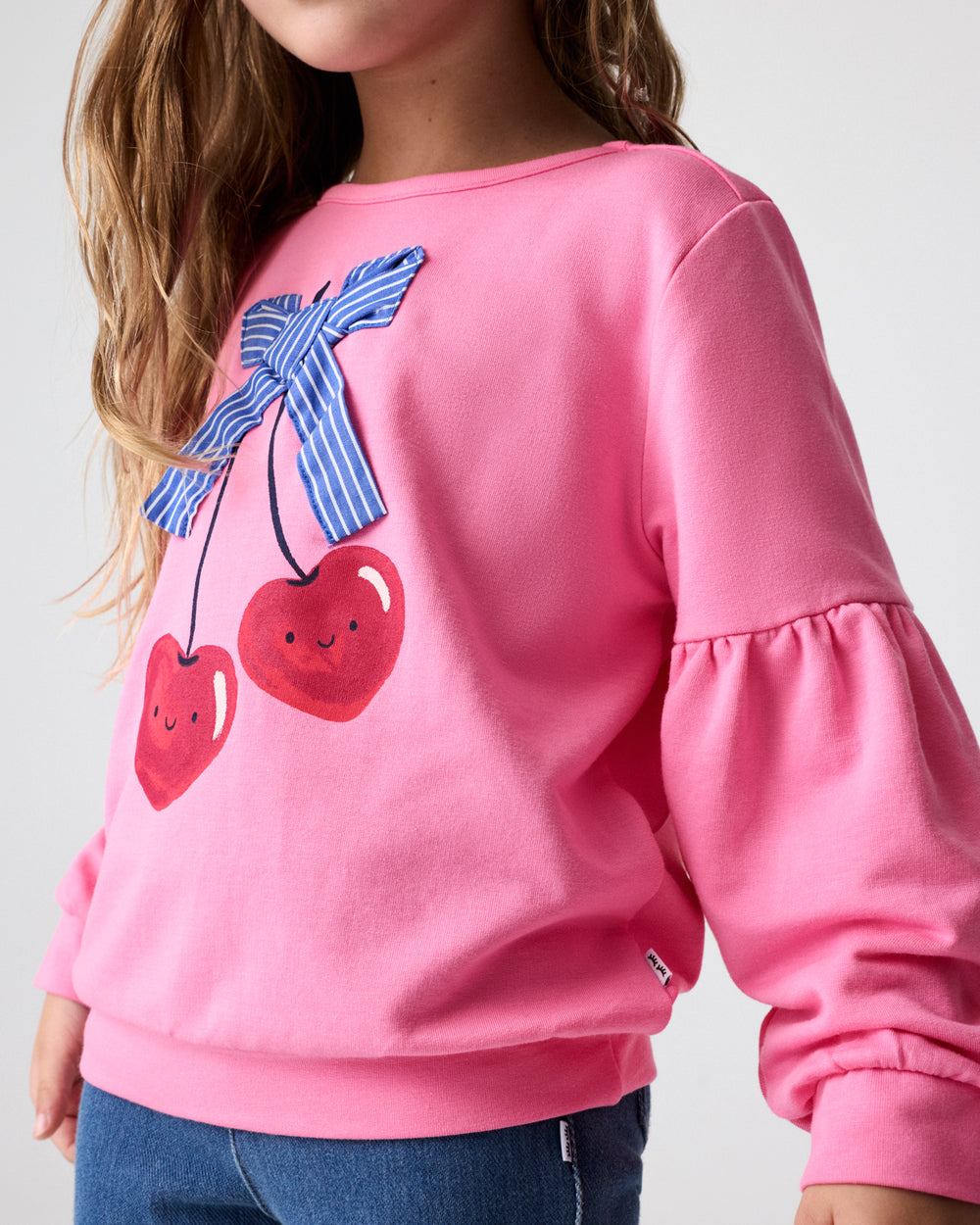 Close up of girl wearing the Cherry Charm Drop Shoulder Crewneck