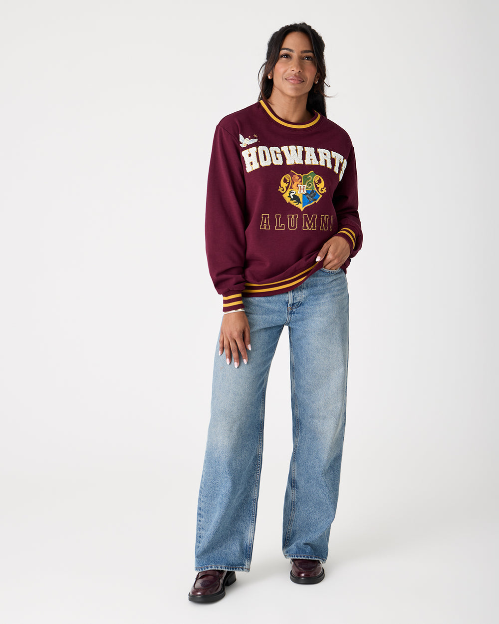 Woman wearing the Harry Potter™ Spellbinding Studies Adult Crewneck Sweatshirt with denim pants
