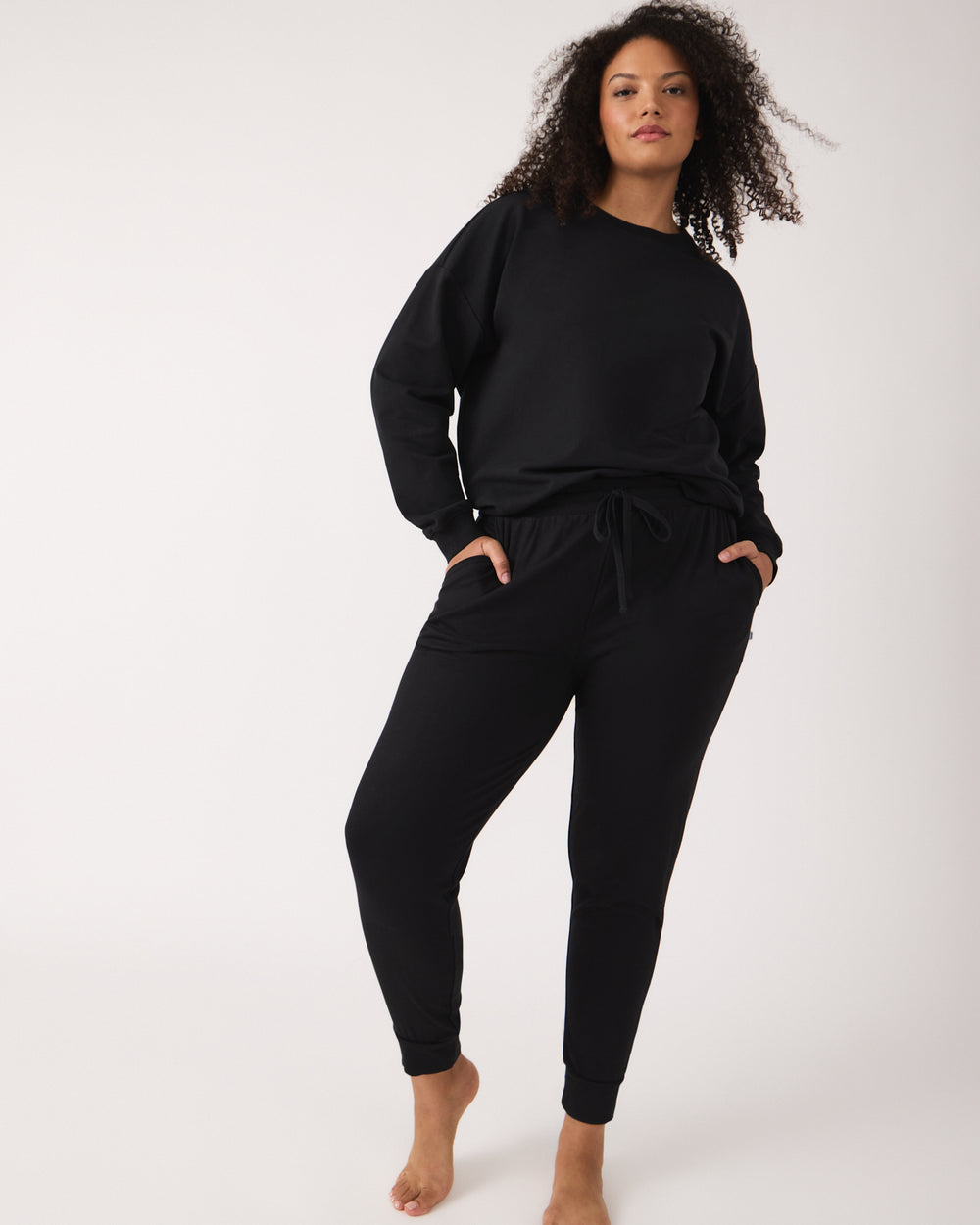 Standing woman wearing the Black Women's Everyday Crewneck Sweatshirt and Jogger