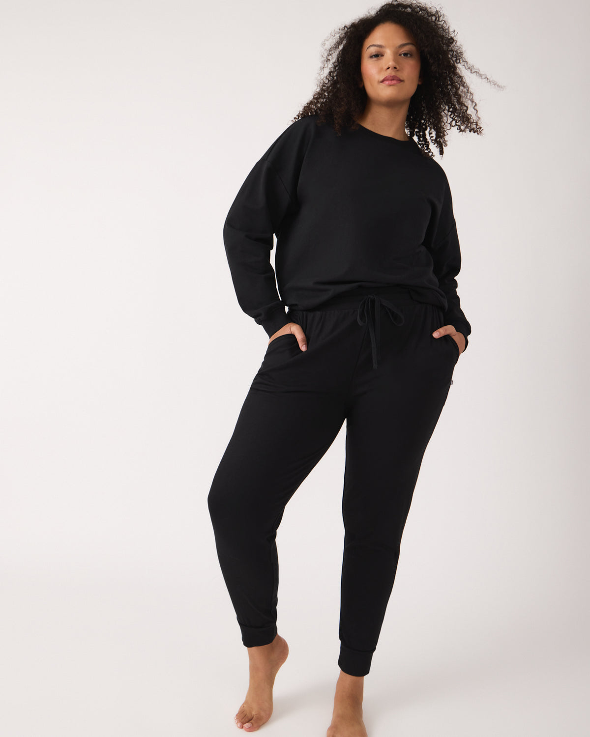 Standing woman wearing the Black Women's Everyday Crewneck Sweatshirt and Jogger