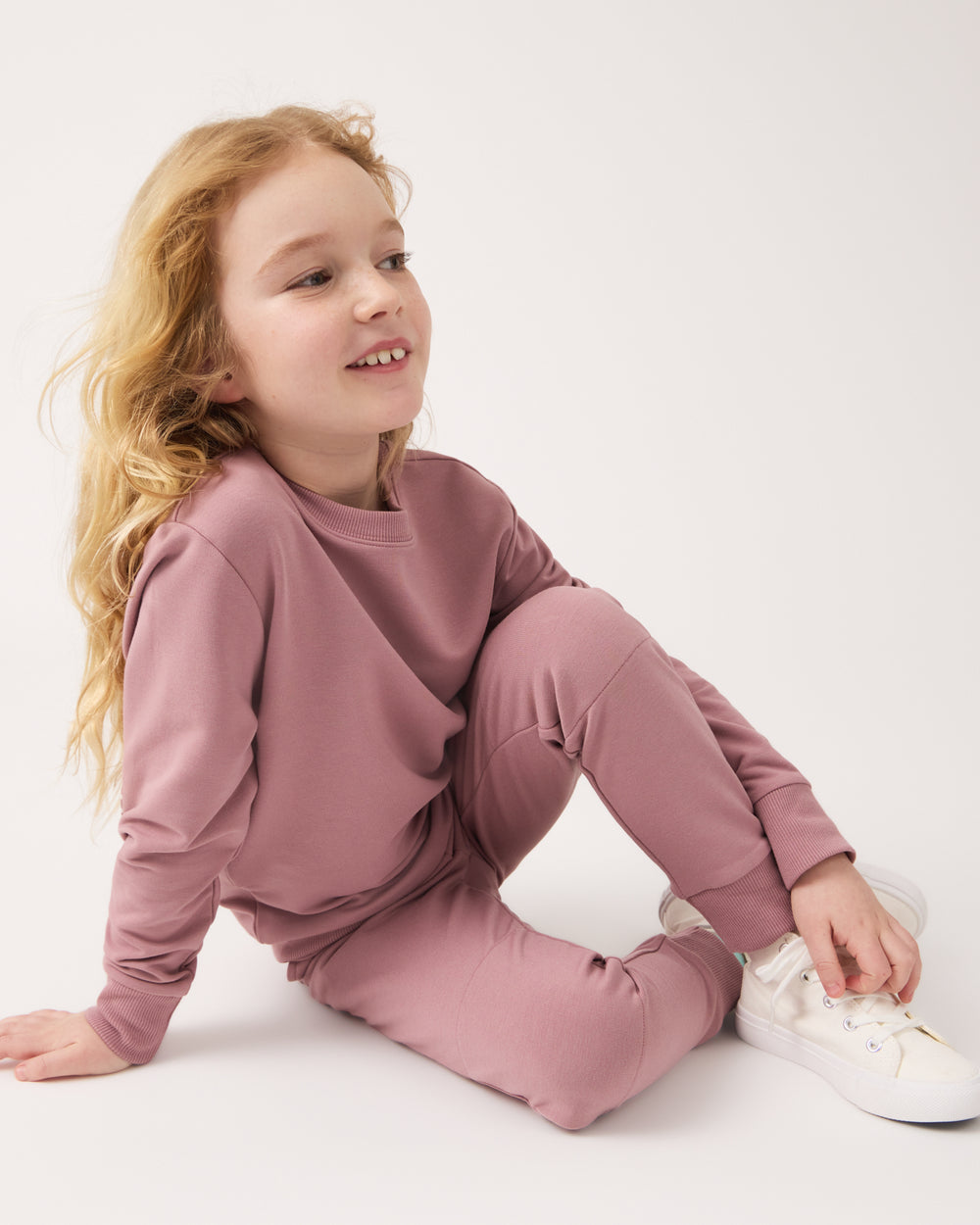 Sitting girl wearing the Rosewood Jogger and Sweatshirt
