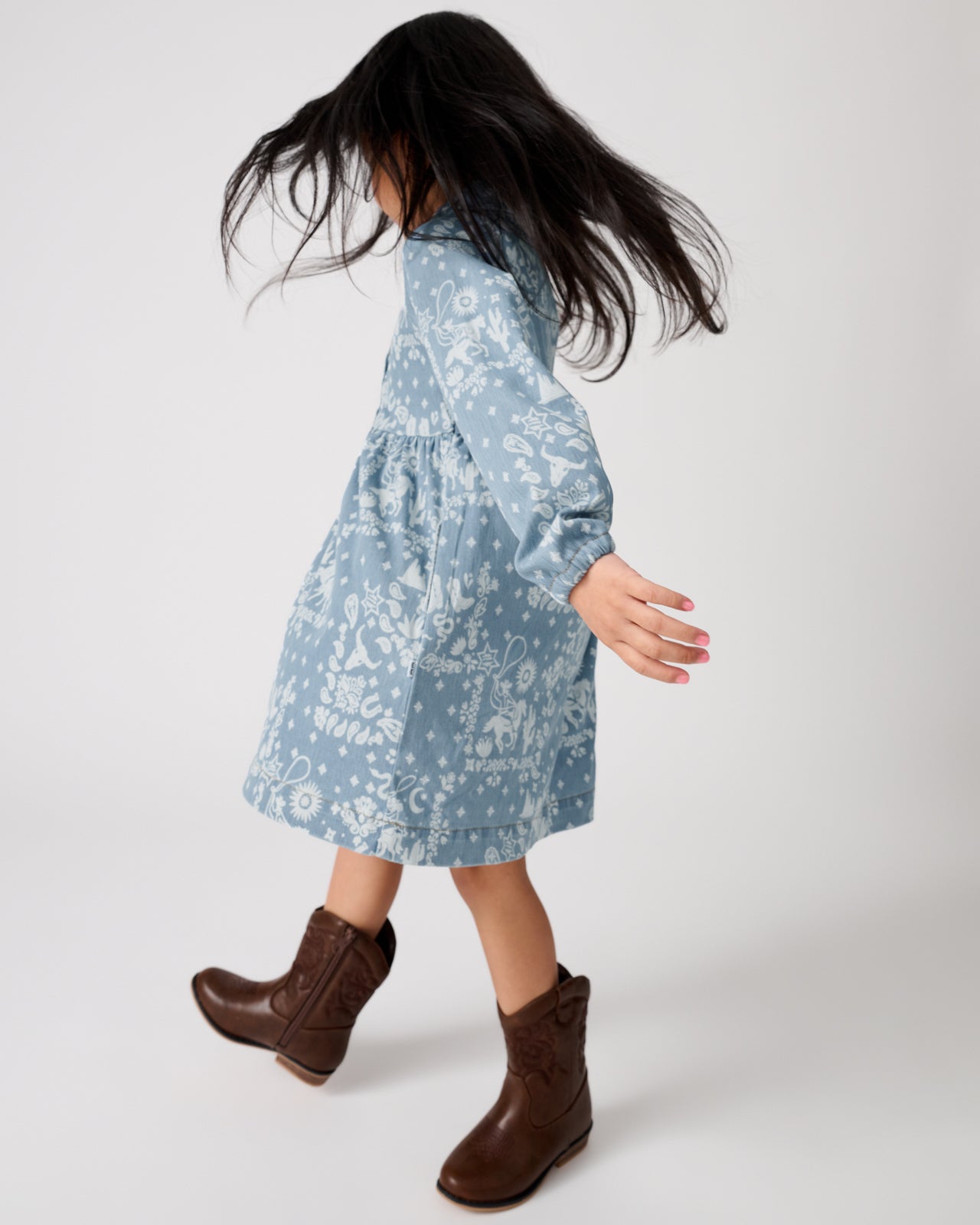 Girl in motion wearing the Bandana Blues Denim Shirt Dress with western leather boots