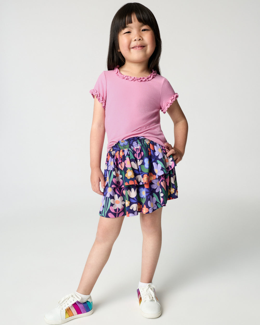 Girl wearing the Wild Garden Tiered Skort with a pink ruffle tee