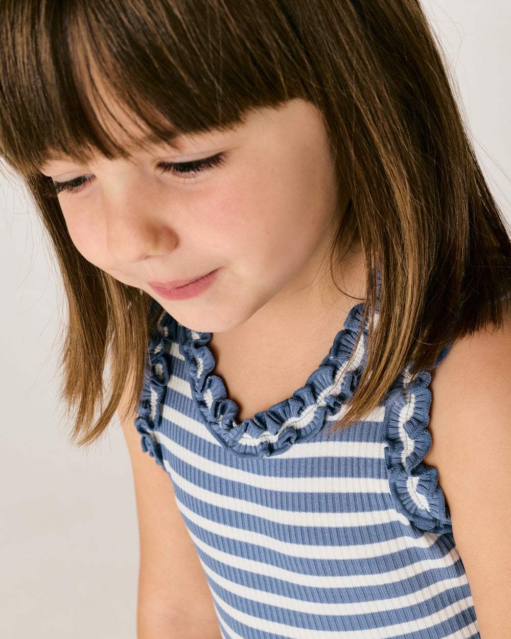 Close up of the ruffle details on the Infinite Blue Stripe Ribbed Ruffle Tank