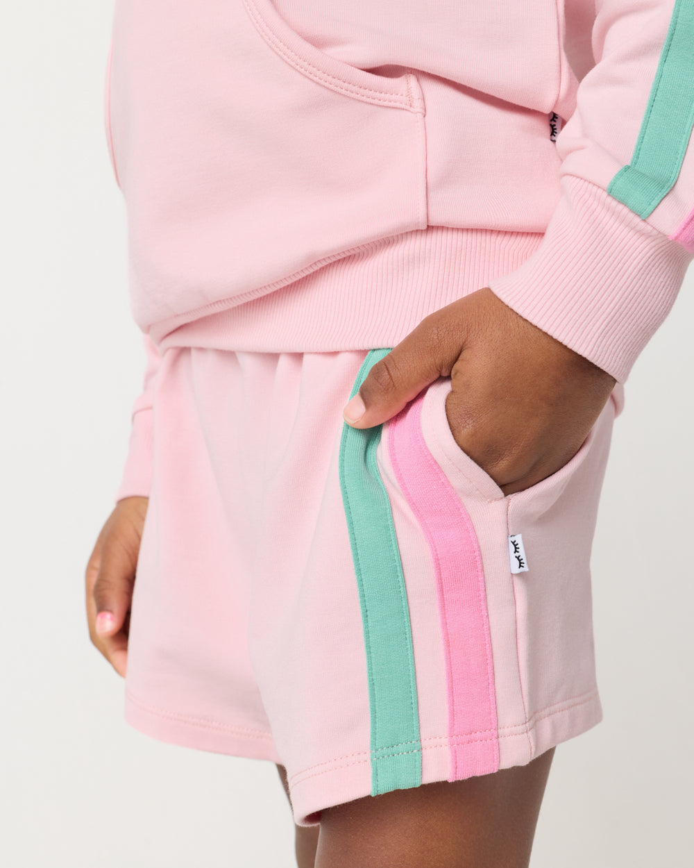 Close up of girl wearing the Pink Blossom Side Stripe Short with her hand in the pocket