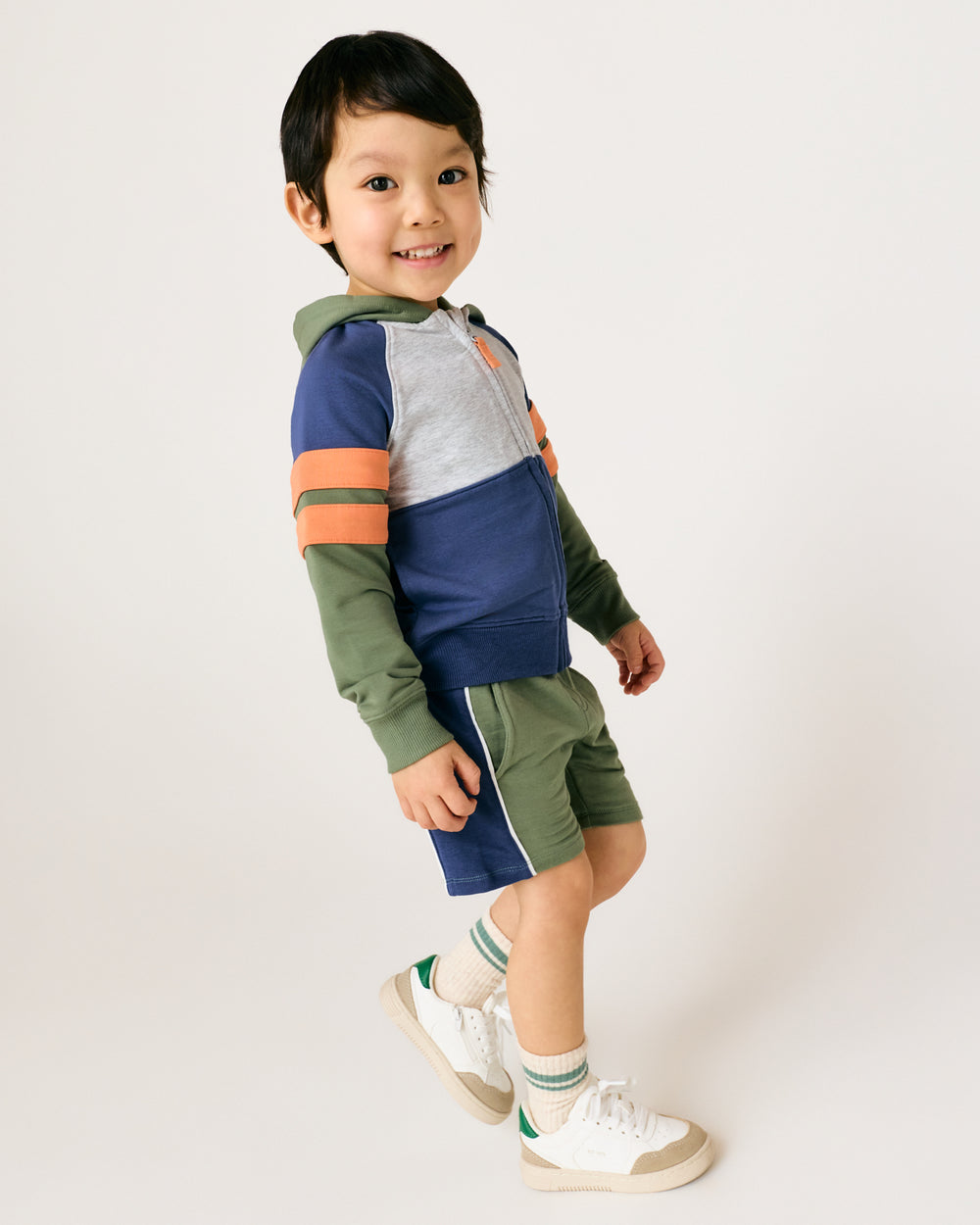 Standing boy wearing the Moss Colorblock Zip Hoodie with matching shorts