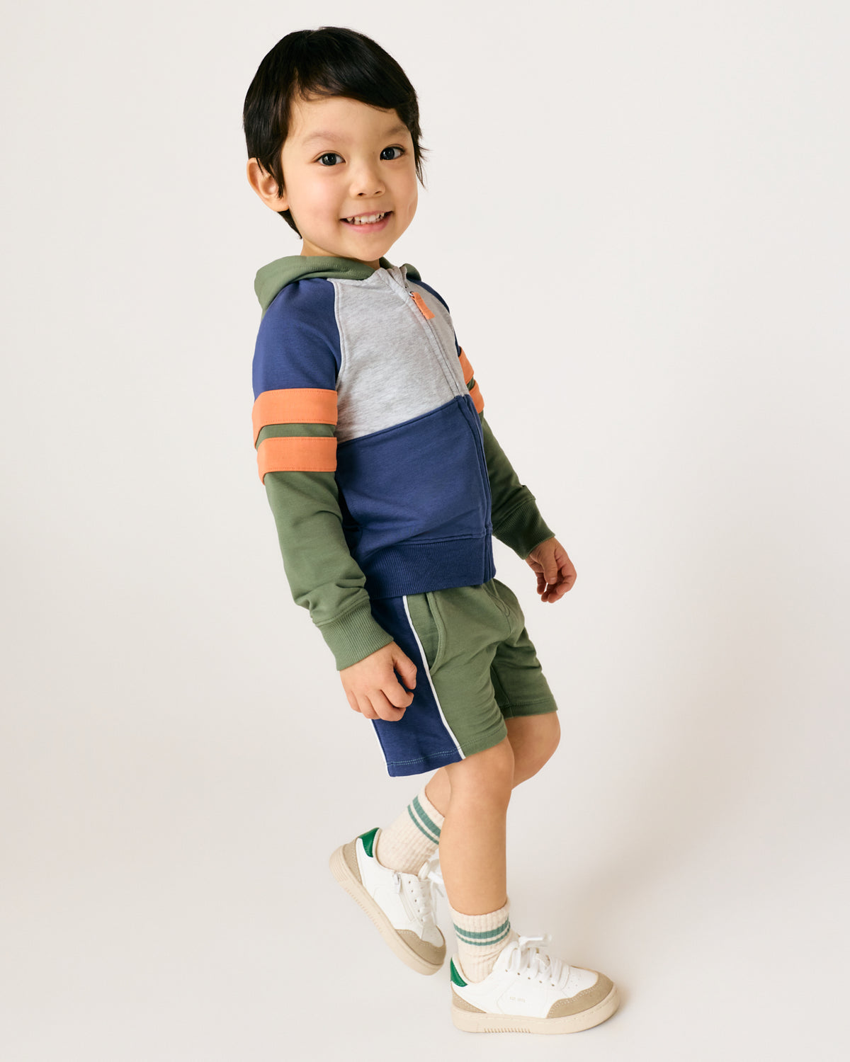 Standing boy wearing the Moss Colorblock Zip Hoodie with matching shorts