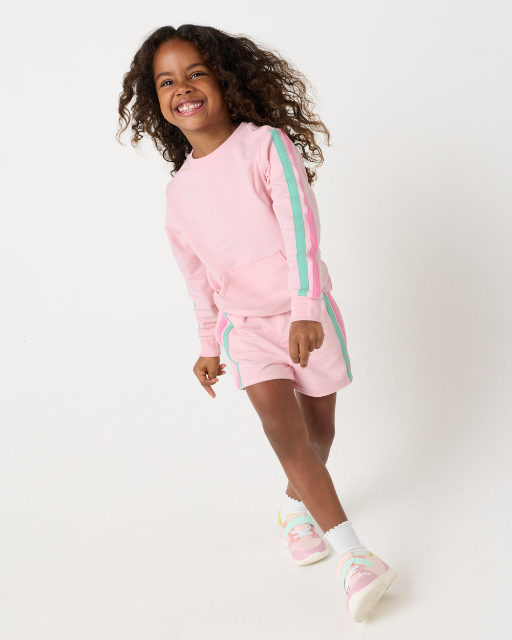 Girl wearing the Pink Blossom Pocket Crewneck and shorts
