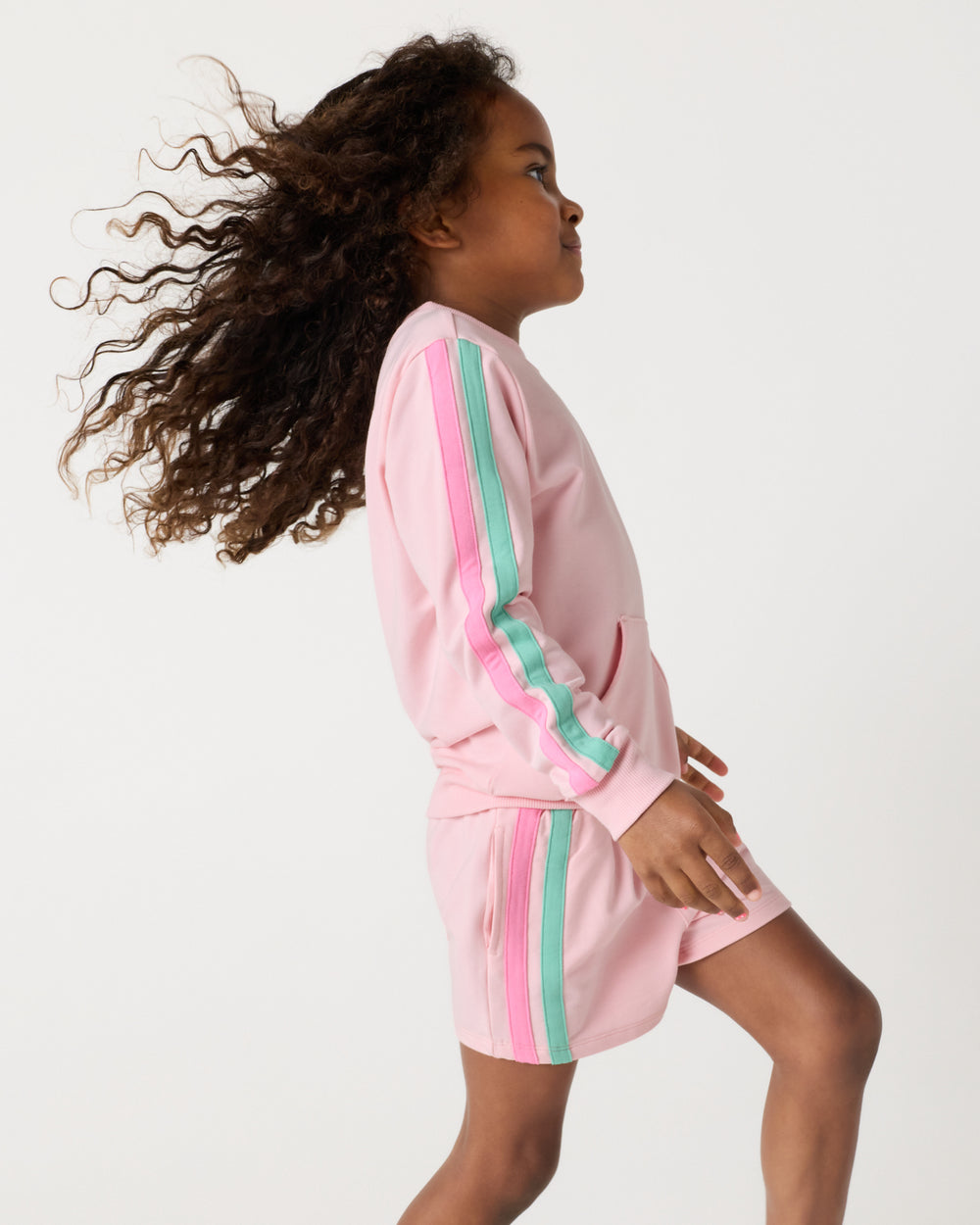 Child in motion wearing the Pink Blossom Pocket Crewneck