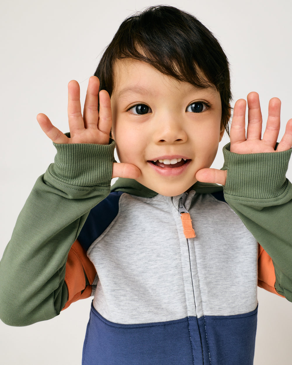 Child holding up his hands showing the thumb holes