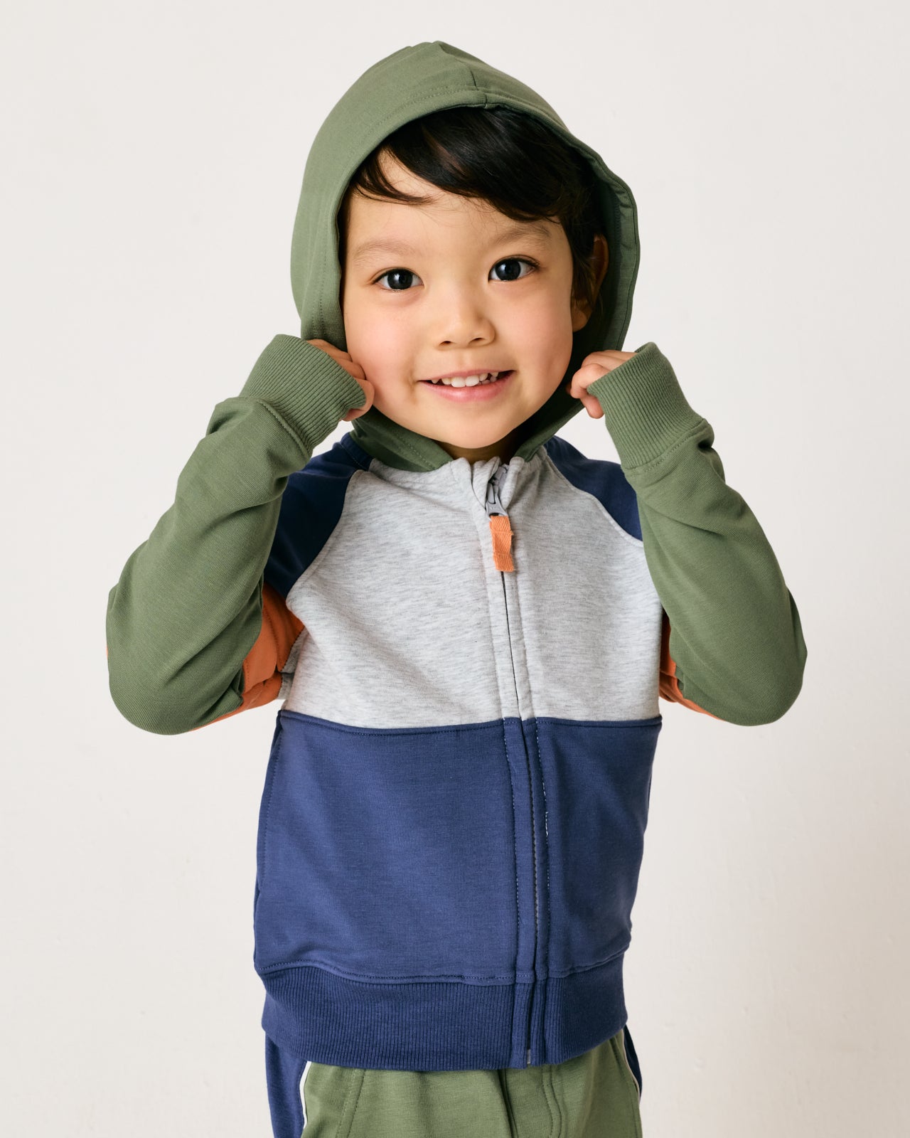 Child wearing the Moss Colorblock Zip Hoodie with the hood on