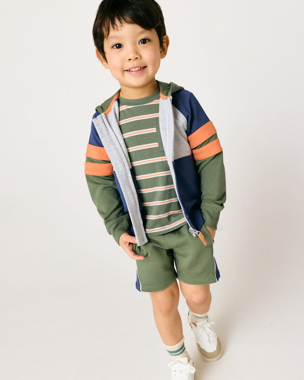 Child wearing the Moss Colorblock Zip Hoodie layered over a striped tee