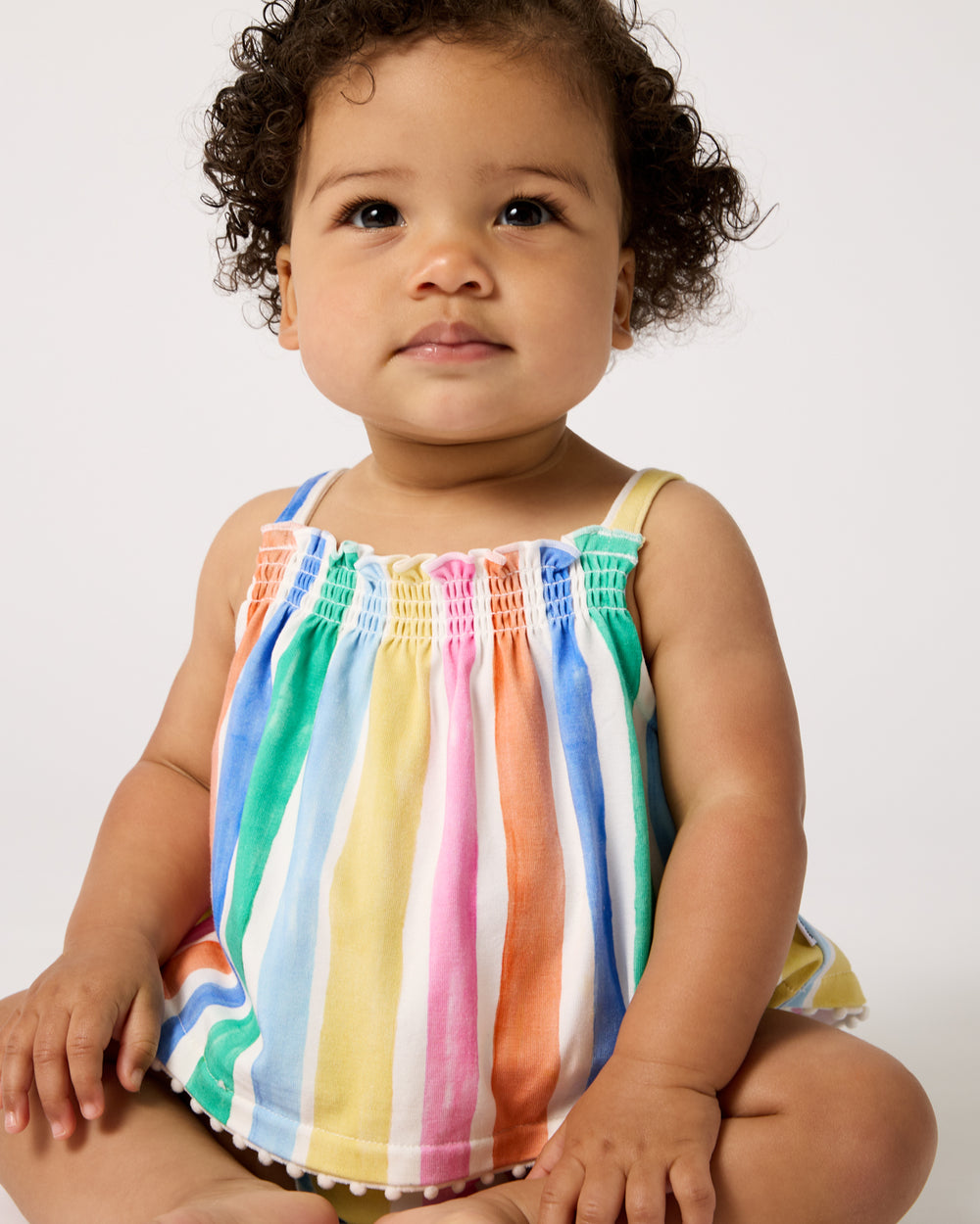 Sitting baby wearing the Rainbow Ribbon Smocked Top with Bloomer
