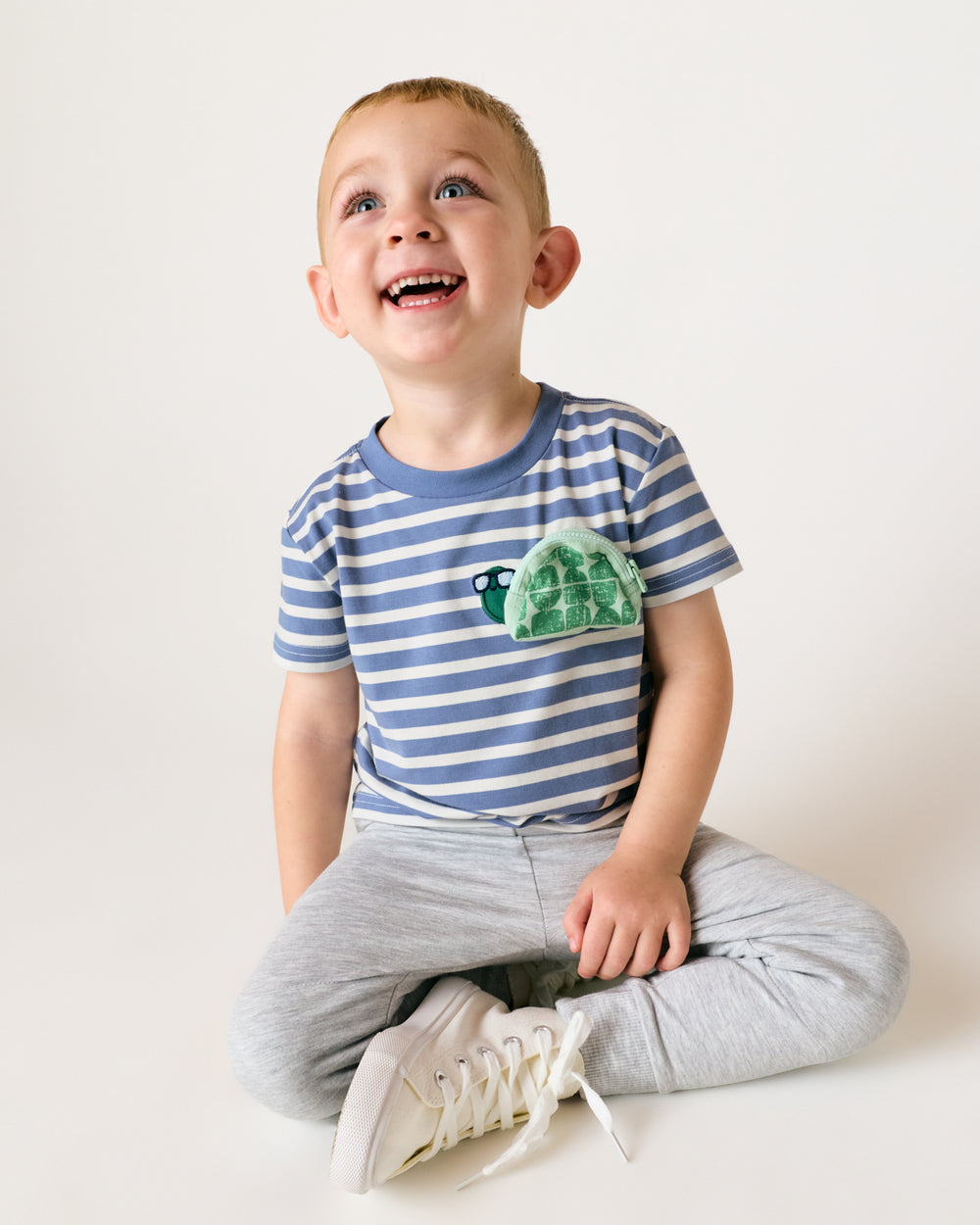 Sitting boy wearing the Zippy Turtle Relaxed Pocket Tee