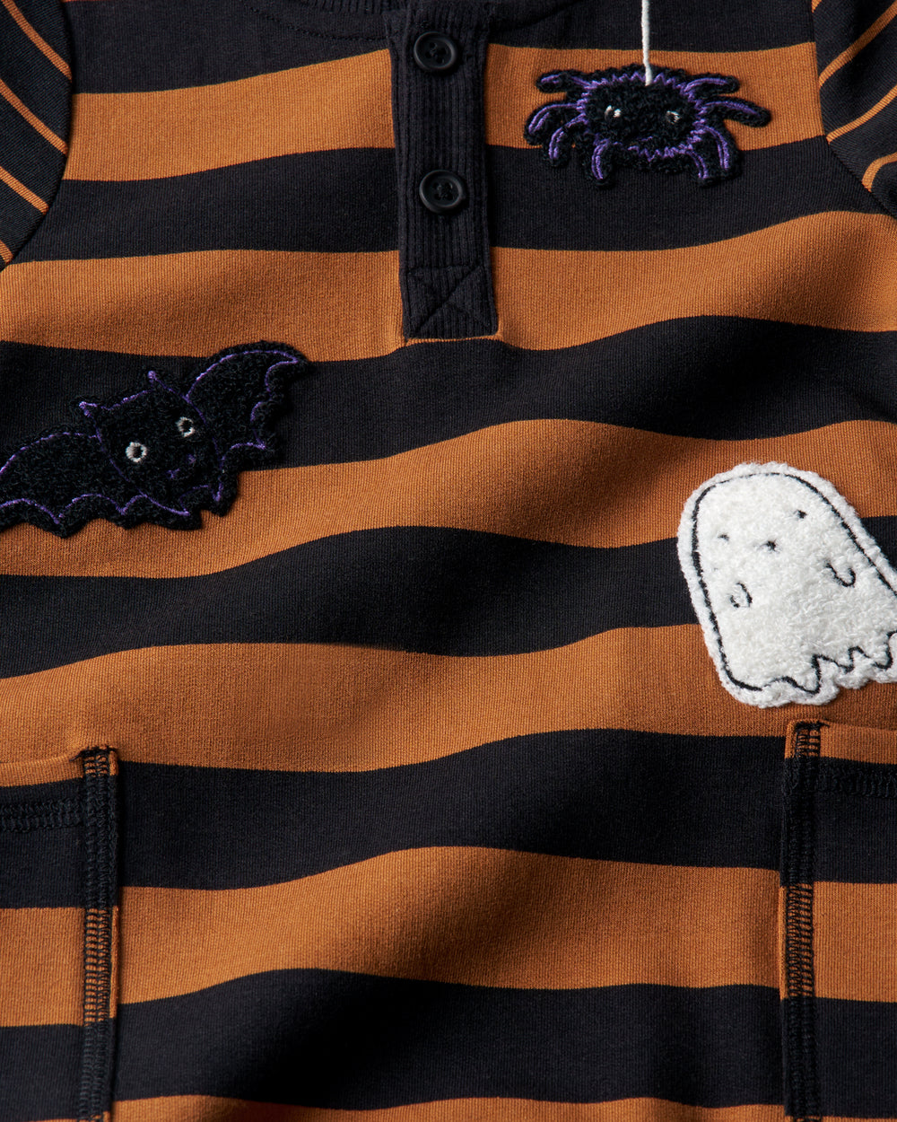 Close up of the graphic details on the Spooky Stripes Henley Romper