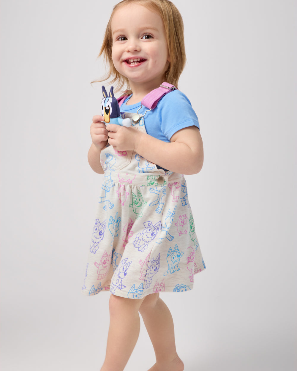 Toddler wearing the Bluey Playtime Crew Skirt Overall over a blue onesie