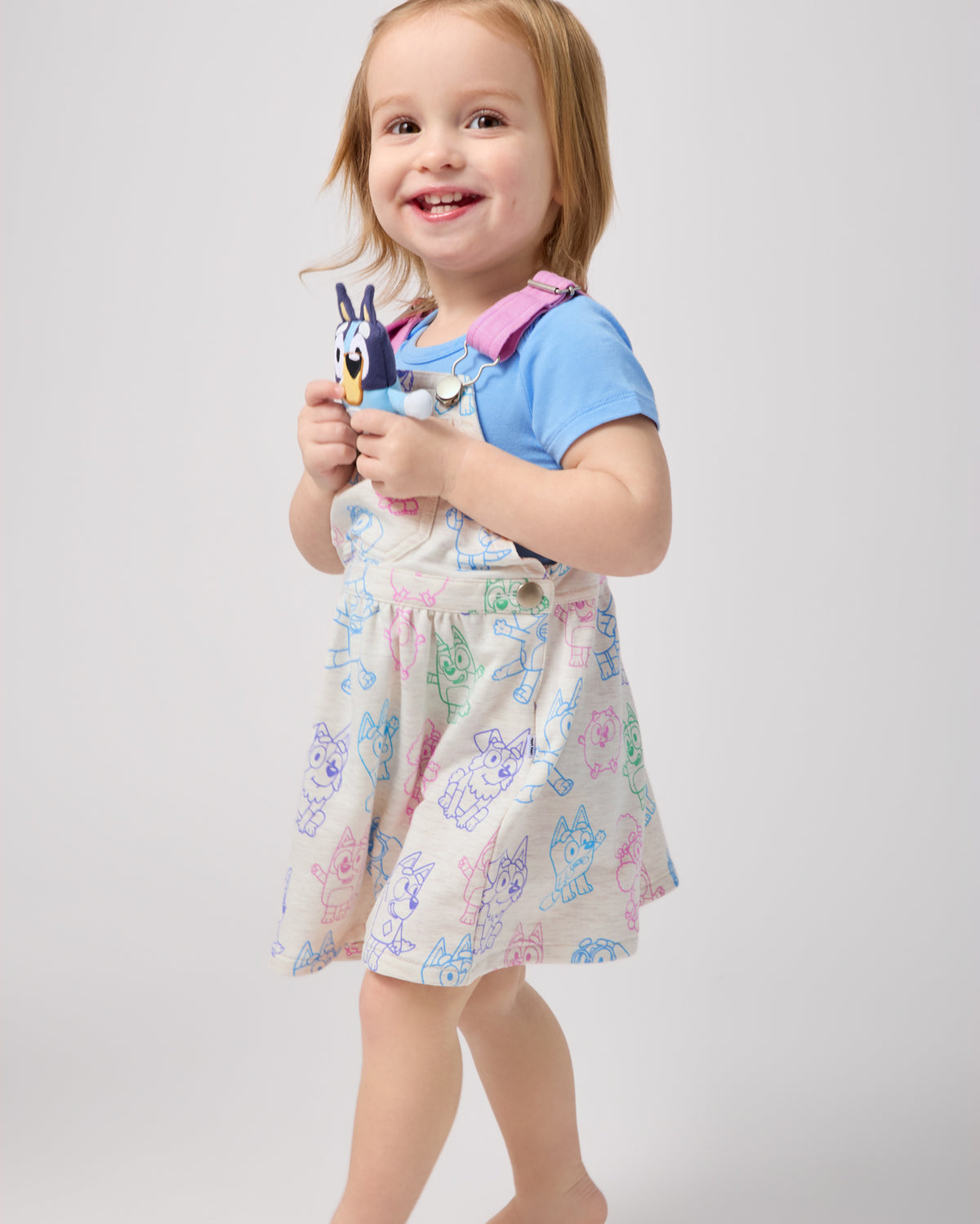 Toddler wearing the Bluey Playtime Crew Skirt Overall over a blue onesie