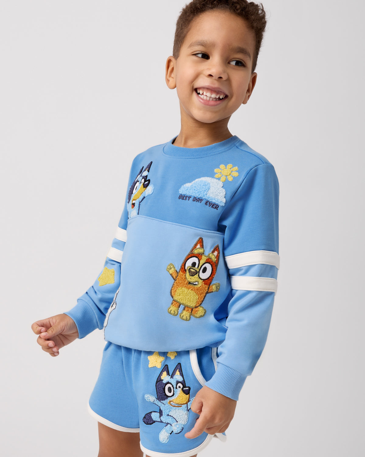 Boy wearing the Bluey Best Day Ever Crewneck Sweatshirt and Dolphin Shorts