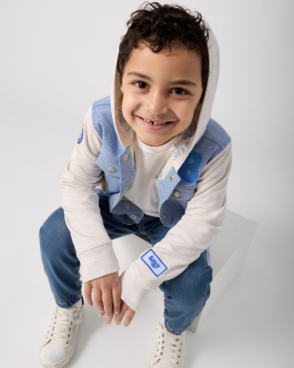 Boy wearing the Bluey Hooded Trucker Jacket layered over a white tee