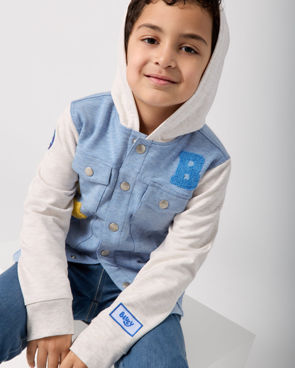 Boy wearing the Bluey Hooded Trucker Jacket buttoned up