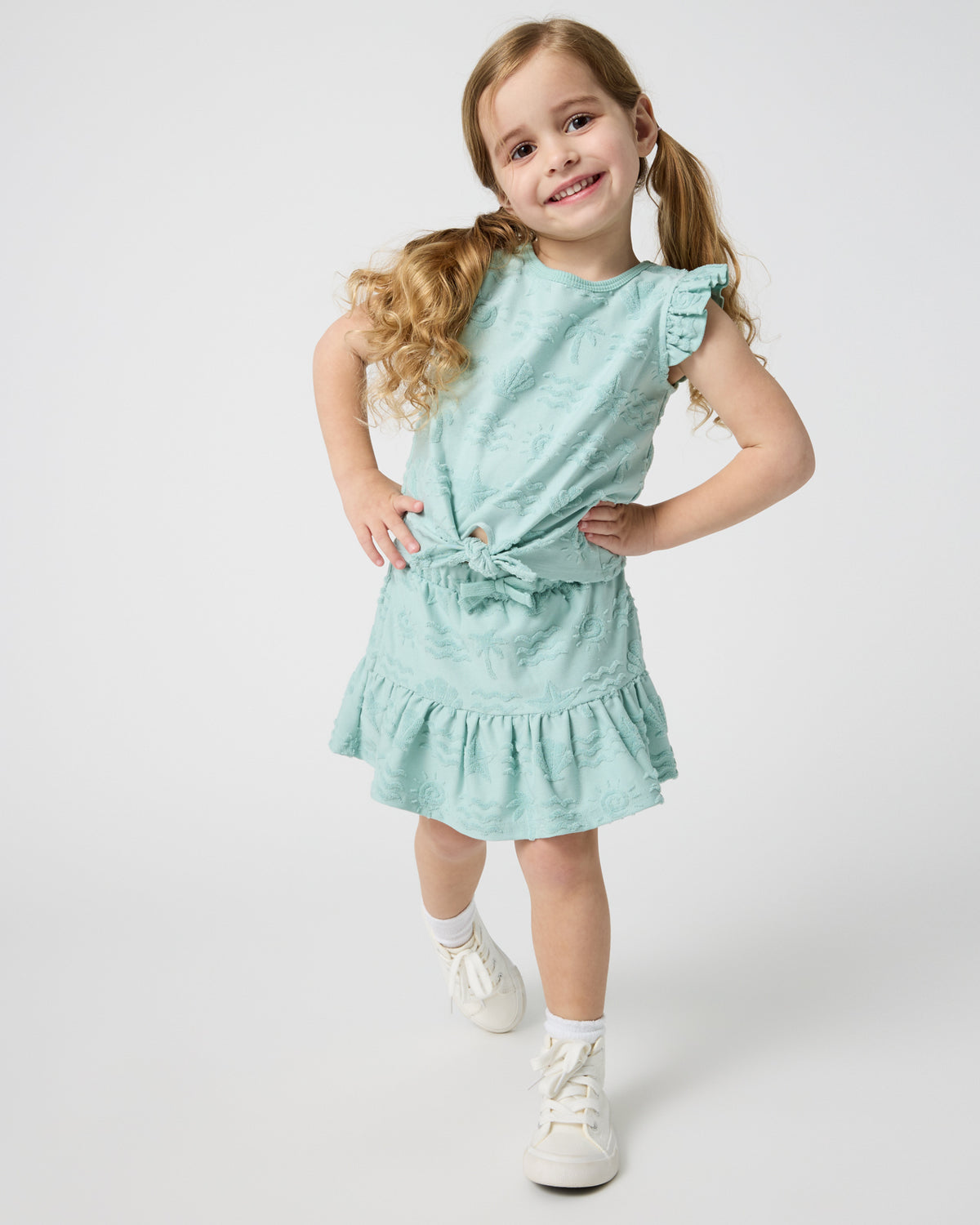Girl wearing the Coastal Rays Flounce Skort and Bow Front Flutter Top