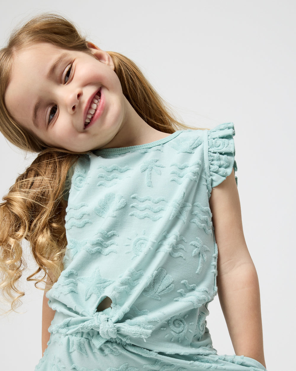 Close up of girl wearing the Coastal Rays Bow Front Flutter Top