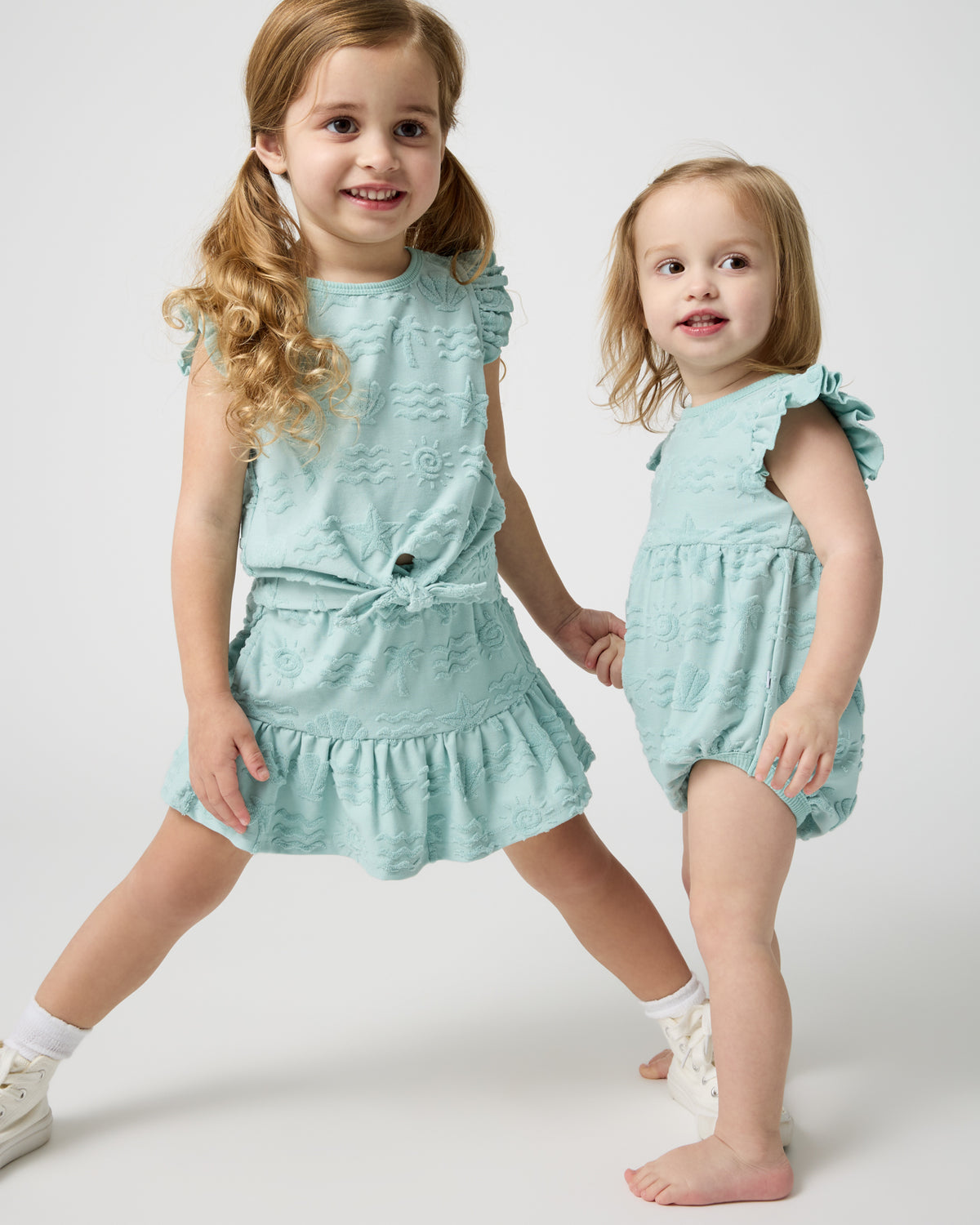 Two children wearing matching Coastal Rays summer styles