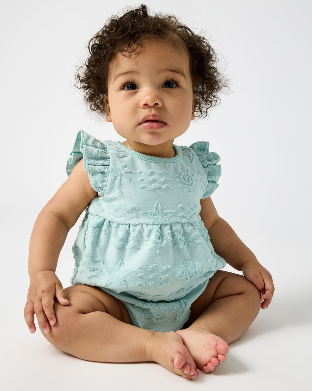 Sitting baby wearing the Coastal Rays Flutter Bodysuit