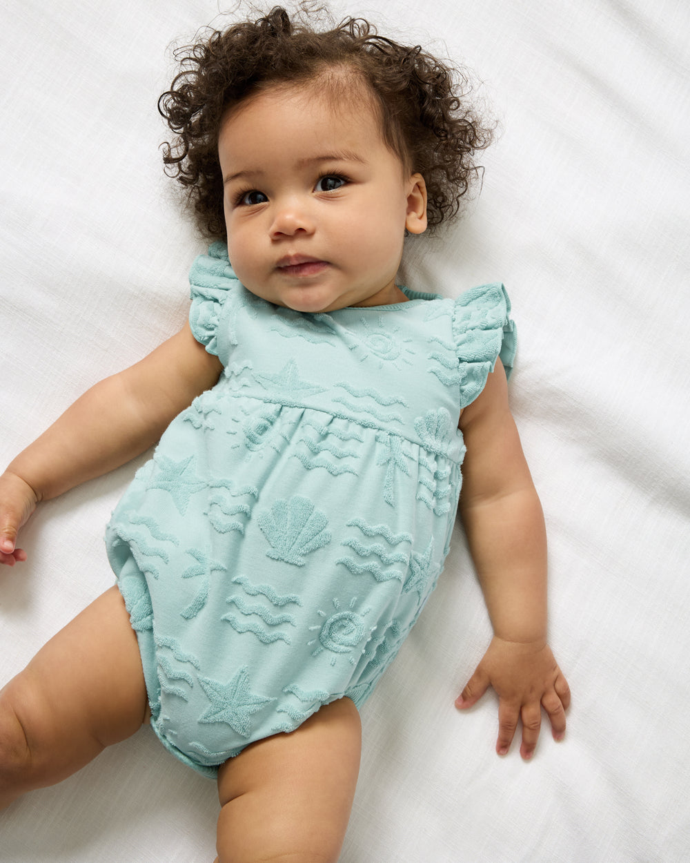 Aerial view of baby wearing the Coastal Rays Flutter Bodysuit