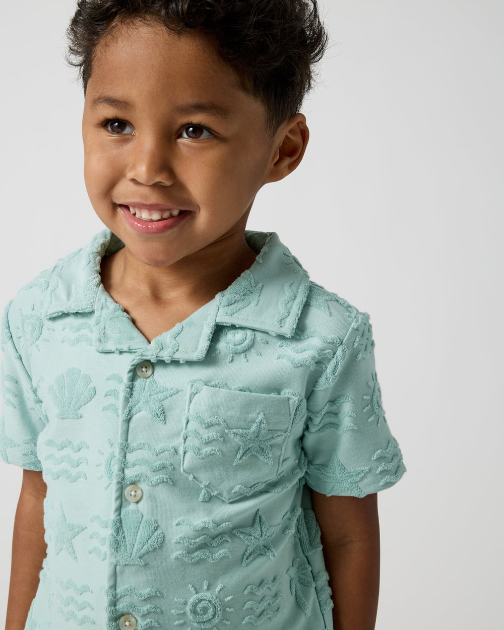Close up of boy wearing the Coastal Rays Button Down Polo