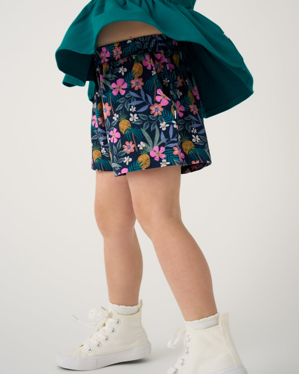 Girl wearing the Tropical Garden Smocked Shorts with white sneakers