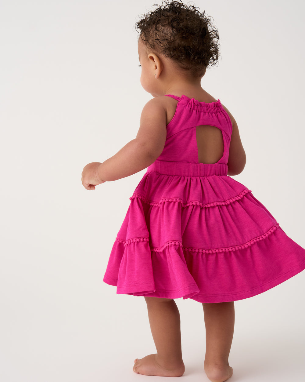 Back view of toddler wearing the Pink Punch Open Back Tiered Dress with Bloomer