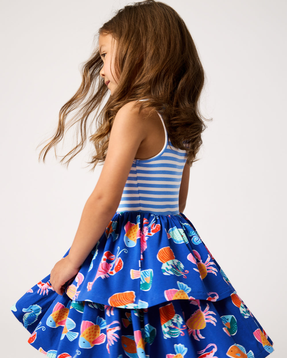 Twirling girl wearing the Tidepool Party Tiered Dress