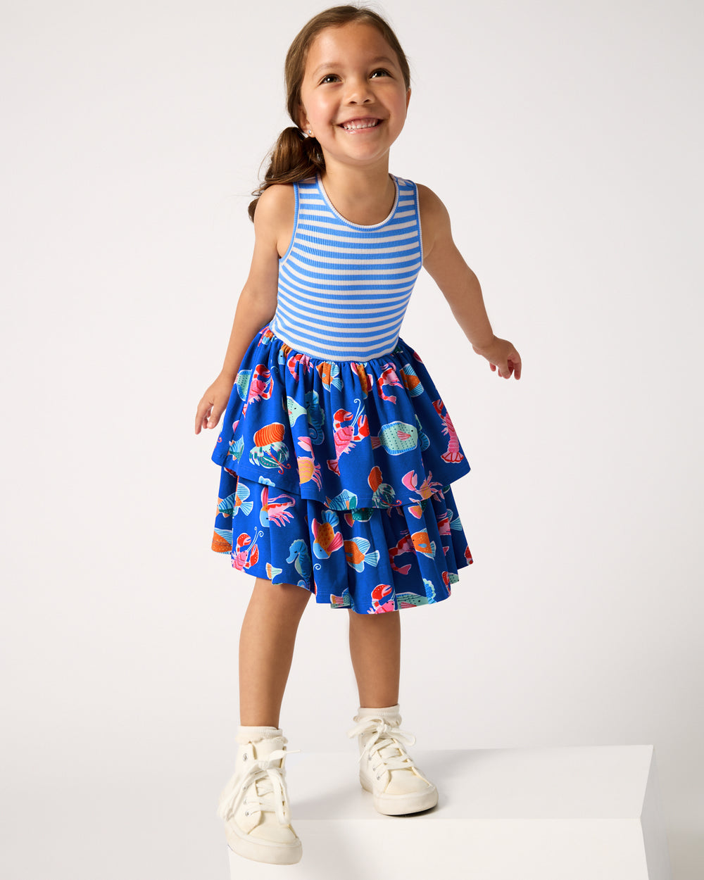 Girl wearing the Tidepool Party Tiered Dress with white sneakers