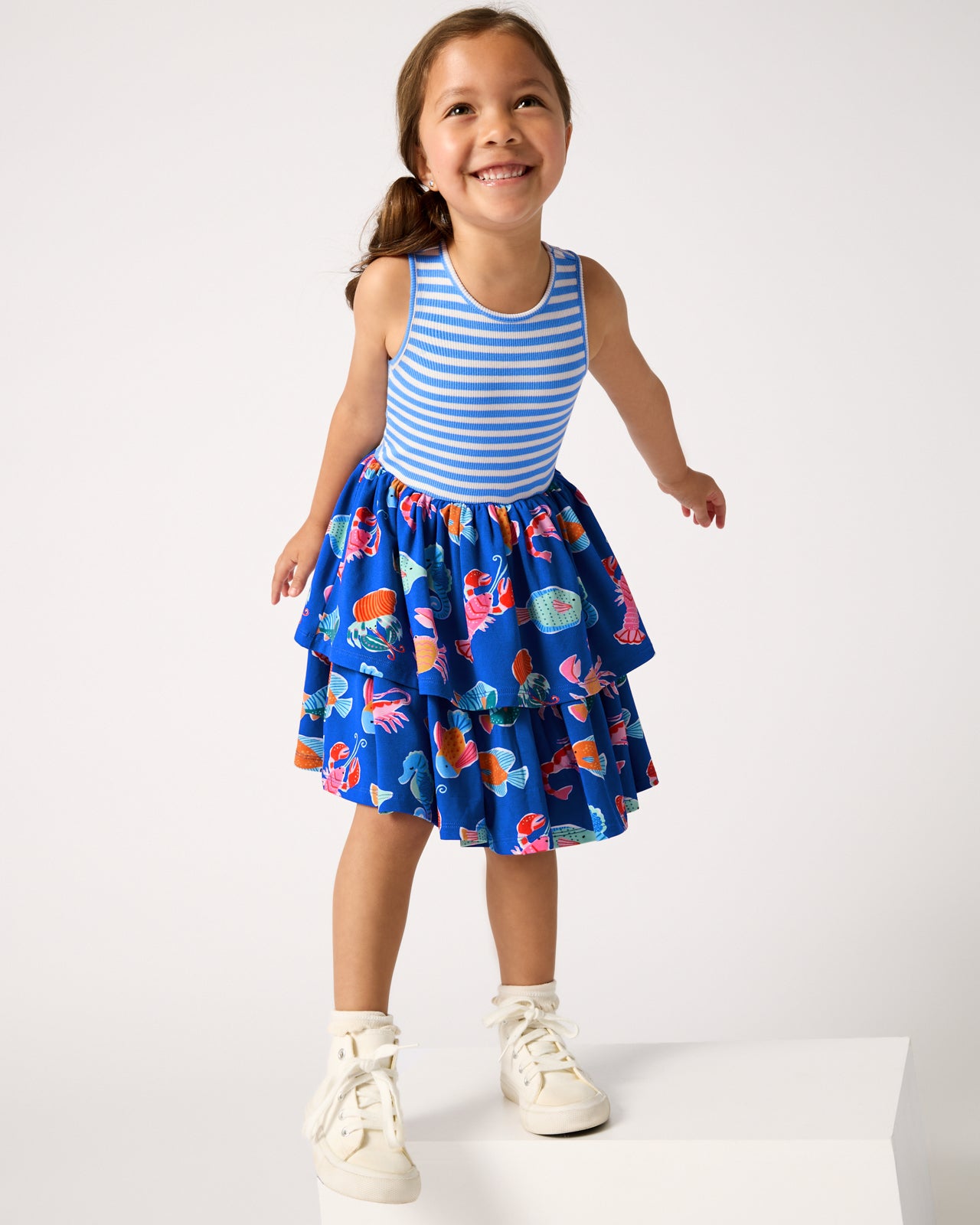 Girl wearing the Tidepool Party Tiered Dress with white sneakers