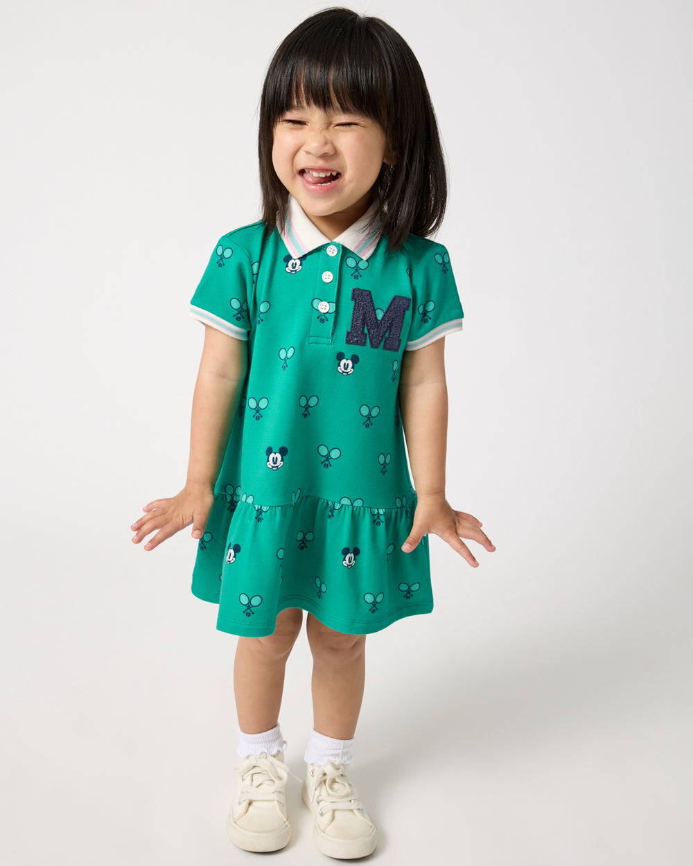 Girl wearing the Disney Mickey Mouse Racket Rally Drop Waist Dress with white sneakers