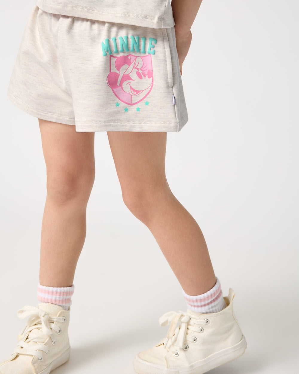 Girl wearing the Disney Minnie Mouse Queen of Swing Athletic Short with white sneakers
