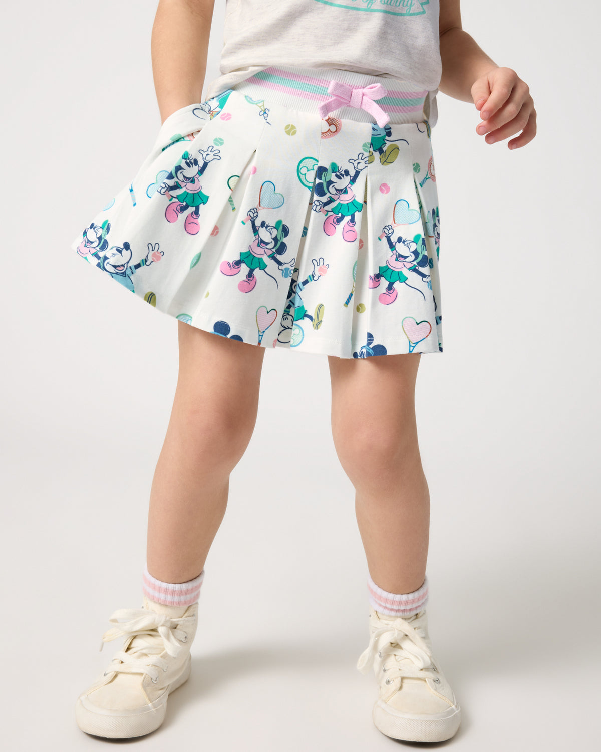 Girl wearing the Disney Mickey Mouse & Minnie Mouse Match Pleated Skort with white sneakers
