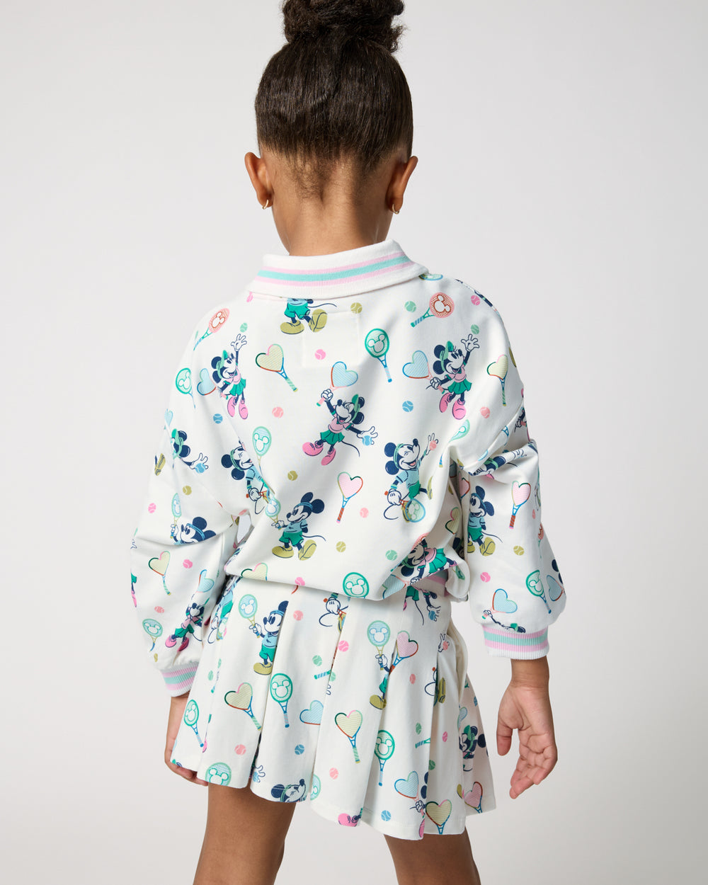 Back view of girl wearing the Disney Mickey Mouse & Minnie Mouse Match Drop Shoulder Crewneck and Skort