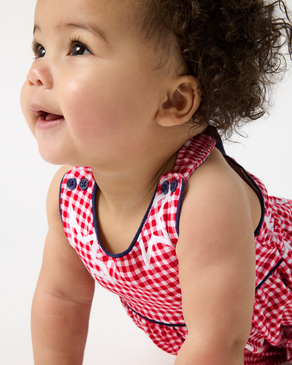 Close up of baby wearing the Celebration Gingham Bow Back Bubble Romper