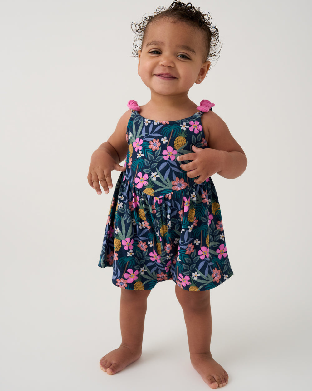 Toddler wearing the Tropical Garden Baby Bow Strap Romper